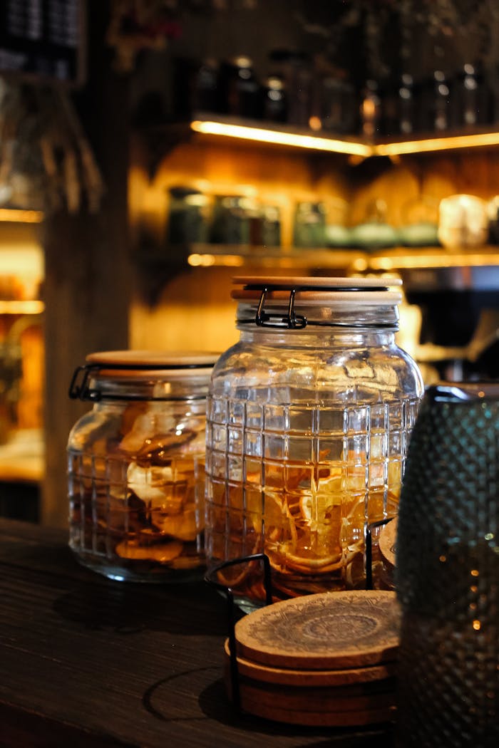 Services-03 Warm cafe interior in Wrocław, featuring jars filled with dried citrus slices on a wooden counter.